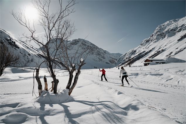 Ski de fond dans la magnifique vallée du Manchet à Val d'Isère avec deux personnes en arrière plan -
