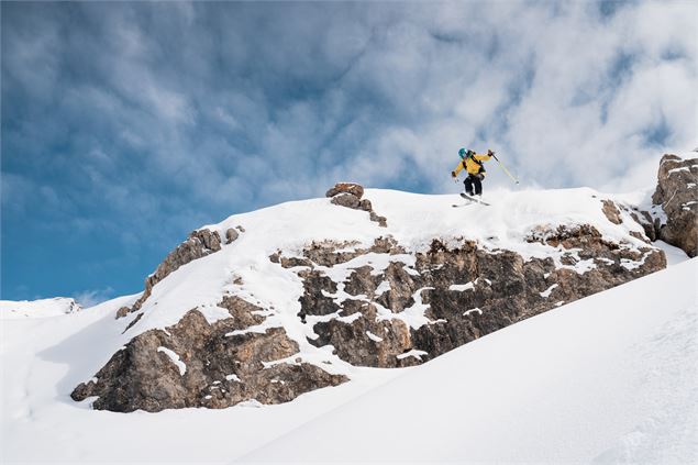 Skieur hors piste qui saute une barre rocheuse. - Yann ALLEGRE