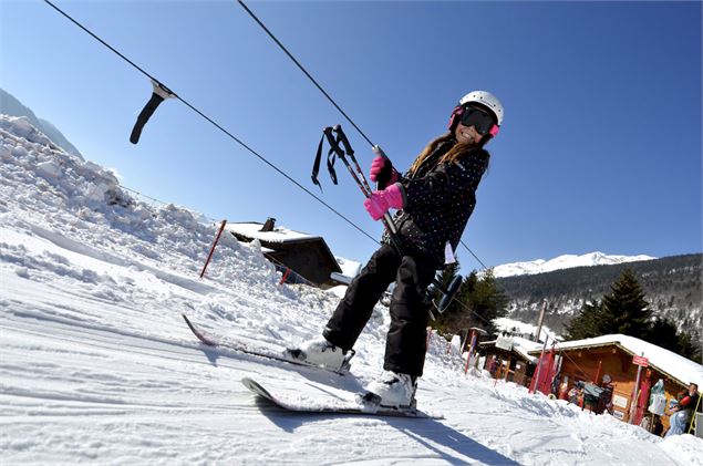 Un skieur remonte en téléski sur le domaine skiable débutants Le Grand-Bornand - Marc Verpaelst