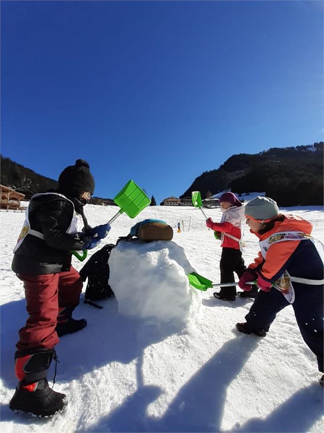 Les enfants construisent un bonhomme de neige - M.Ghezli - Mairie de Châtel