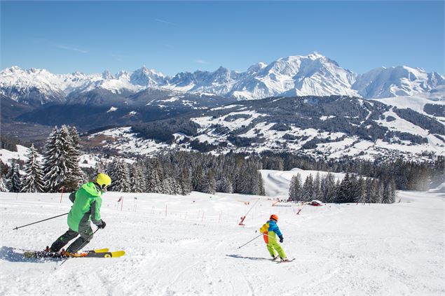 Famille de skieurs face au Mont-Blanc sur la piste bleue de la Bel Ava - Soren Rickards