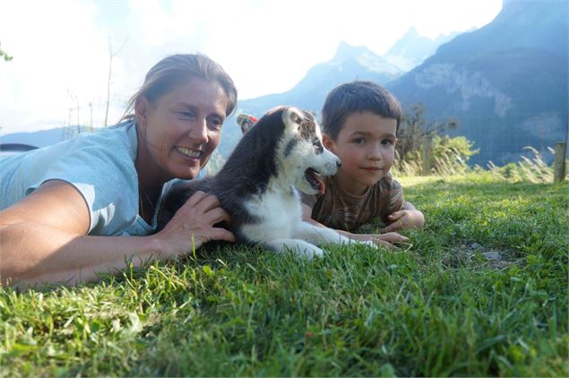 Allongés dans l'herbe avec un chiot tout mignon - Les Grange d'Heïdi