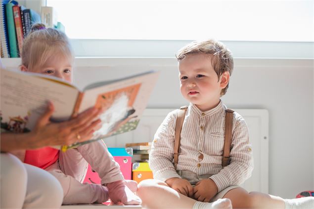 Enfant assis regardant un livre - Freepik