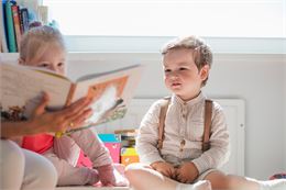 Enfant assis regardant un livre - Freepik