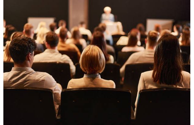 Personne en fond avec public pour une conférence - istockphoto_Crédits skynesher