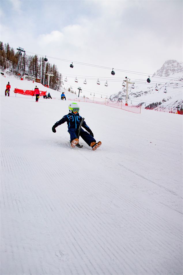 Enfant sur un Yooner à Val d'Isère en hiver sur la piste de la Savonnette - Angèle Barreira