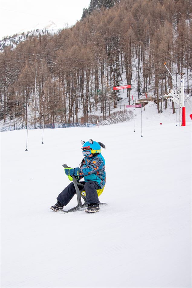 Enfant sur un Yooner à Val d'Isère en hiver sur la piste de la Savonnette - Angèle Barreira