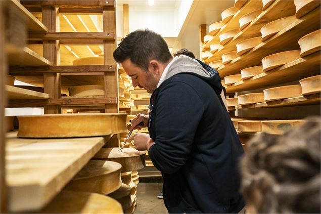 Vincent prélève un peu de fromage Abondance - L.Meyer_Châtel