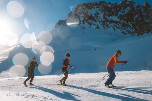 3 skieurs pratiquent le ski de fond sur une piste de skating - Arthur Bertrand