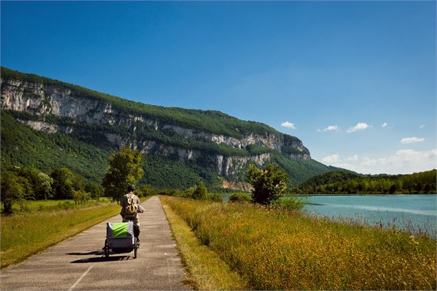 Cycliste avec remorque sur la route près de Balme - Christian Martelet / Auvergne-Rhône-Alpes Touris