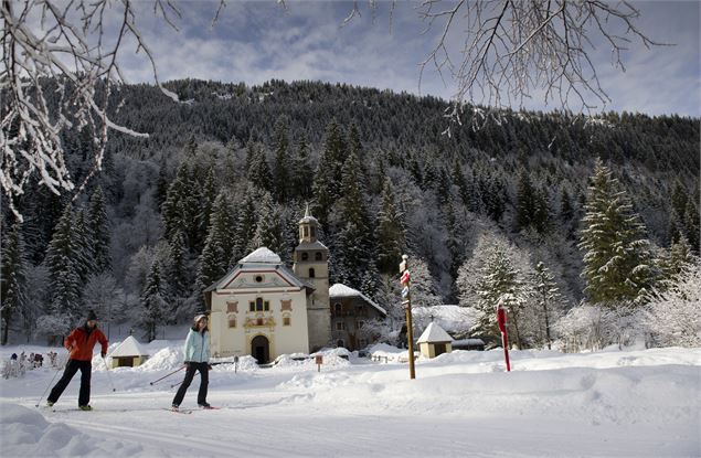 Ski de fond devant l'église de Notre-Dame de la Gorge - Gilles Lansard / Les Contamines Tourisme