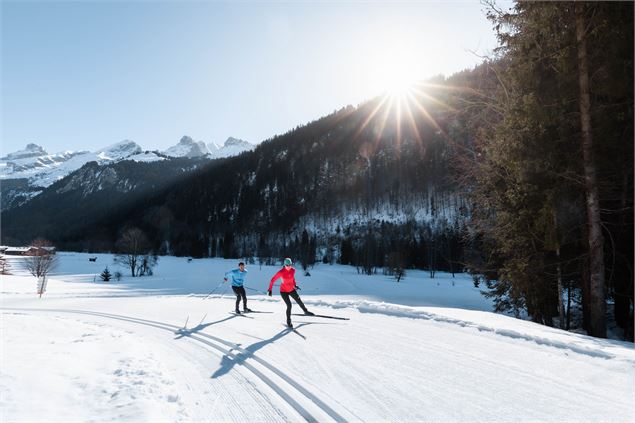 Couple de skieurs sur une piste de Ski nordique ensoleillée au Grand-Bornand - C. Hudry