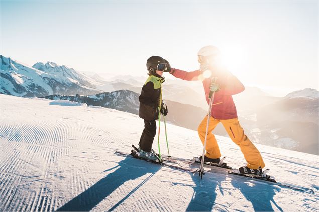 ski alpin au Grand-Bornand au coucher de soleil en famille face à la chaîne des Aravis - T.Shu