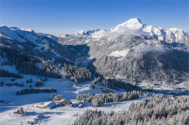 Vue aérienne sur l'arrivée de télécabine de Super-Châtel et quelques pistes avec le village en arriè